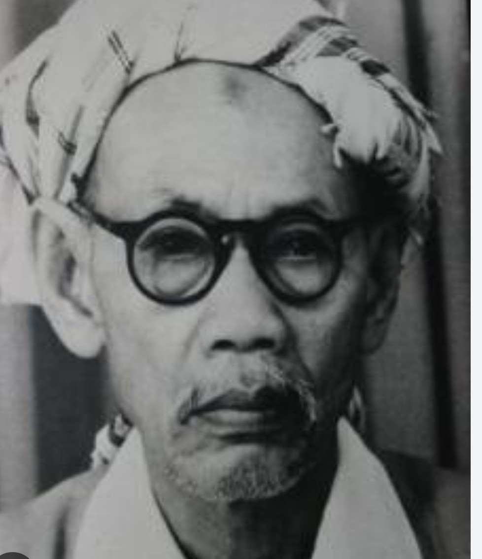 Portrait of mahatma gandhi wearing round glasses and a cloth on his head looking thoughtful